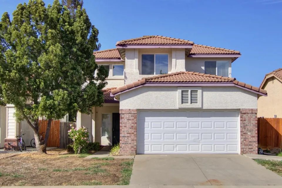 Two-story home with tile roof and two-car garage at 7013 Sandy Souza Way, Elk Grove, California